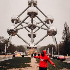 Arms open in front of the Atomium in Brussels